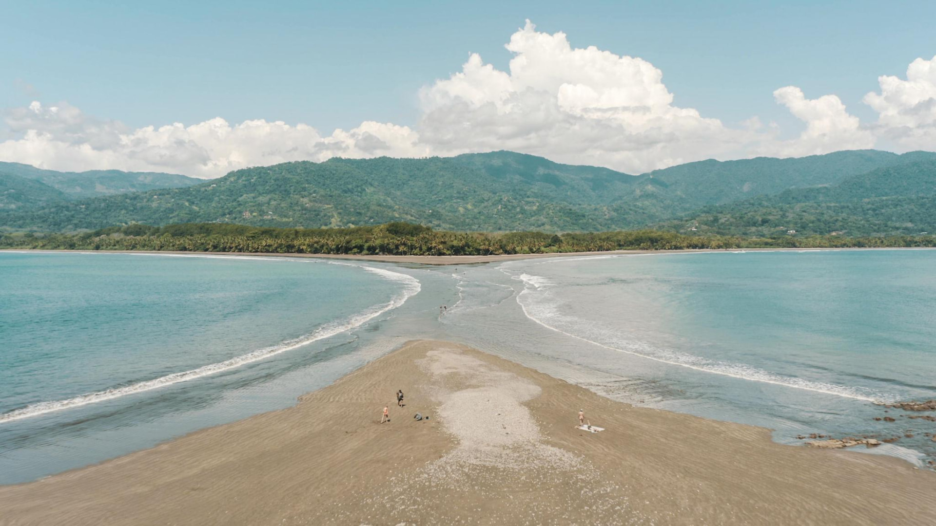 Aerial view of a sandbar meeting turquoise water in a Costa Rican bay