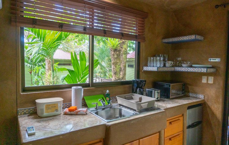 Villa kitchen with a window overlooking tropical greenery