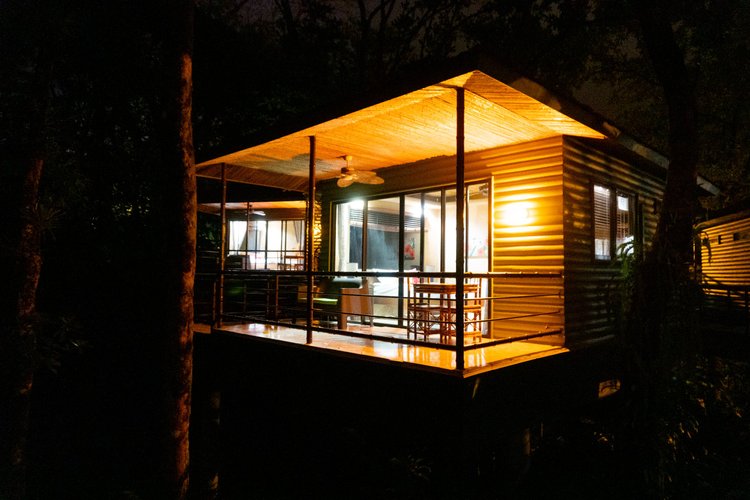 Villa deck glowing with warm light in the jungle at night
